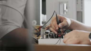 Bir mühendis ya da teknisyen arıza için hatalı bir cihazı test eder. Mühendis özel bir cihazla mikro devreyi kontrol ediyor.. 