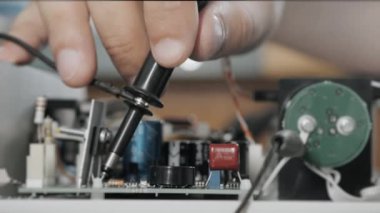 Bir mühendis ya da teknisyen arıza için hatalı bir cihazı test eder. Mühendis özel bir cihazla mikro devreyi kontrol eder. Yakın plan..