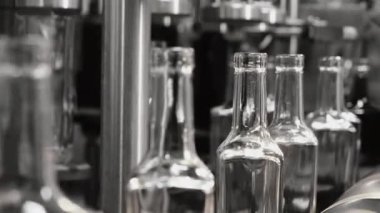 Fabrikadaki içkileri şişelemek için bir teknoloji hattı. Boş dikdörtgen cam şişeler taşıyıcı bant boyunca hareket eder. Fabrikada içecek, su ve limonata için sıra. İçecek üretim tesisi.