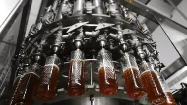 Fabrikadaki içkileri şişelemek için otomatik hat. Plastik şişeler otomatik olarak sıvıyla doldurulur. Fabrikada içecek, su ve limonata için sıra. İçecek üretim tesisi.