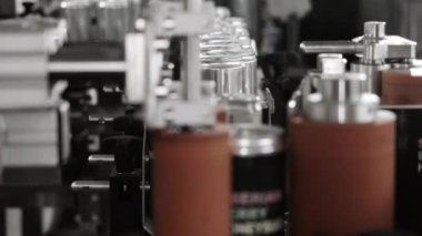 Fabrikada içki ve bira şişelemek için üretim hattı. Dolu alüminyum kutular etiketlenmek üzere taşıyıcı boyunca hareket eder. İçecekler için alüminyum kutular. İçecek üretim ve şişeleme fabrikası.