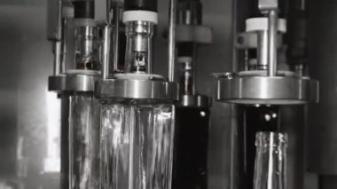 Fabrikadaki içkileri şişelemek için otomatik hat. Cam şişeler otomatik olarak sıvı ile doldurulur. Fabrikada içecek, su ve limonata için şişeleme hattı. İçecek üretim tesisi.