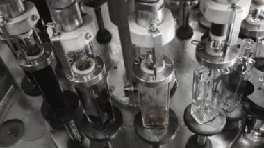 Fabrikadaki içkileri şişelemek için otomatik hat. Cam şişeler otomatik olarak sıvı ile doldurulur. Fabrikada içecek, su ve limonata için şişeleme hattı. İçecek üretim tesisi.