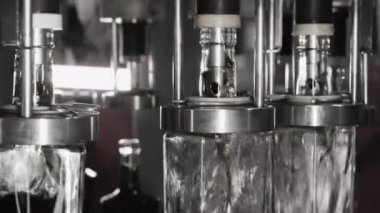 Fabrikadaki içkileri şişelemek için otomatik hat. Cam şişeler otomatik olarak sıvı ile doldurulur. Fabrikada içecek, su ve limonata için şişeleme hattı. İçecek üretim tesisi.