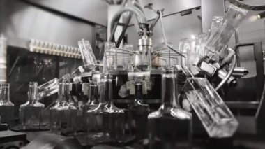 Boş dikdörtgen cam şişeler taşıyıcı bant boyunca hareket eder. Doldurmadan önce şişeleri yıkama işlemi. Fabrikada içecek, su ve limonata için şişeleme hattı. İçecek üretim tesisi.