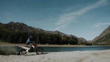 Motokros yarışçılarının kumdaki hareketleri arka tekerlekte duruyor. Kum motosiklet tekerinin altından uçar. Kumda motorun keskin bir başlangıcı..