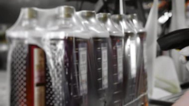 Bir fabrika çalışanı plastik şişeleri içkiyle işaretlemek için tarayıcı kullanır. Fabrikada içki şişelemek için teknolojik bir yöntem. İçecek üretimi.