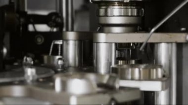 Mantarı şampanya şişelerine bağlama işlemine yakın çekim. Fabrikadaki içkileri şişelemek için bir teknoloji hattı. Fabrikada şampanya ve şarap şişeleme hattı. Köpüklü içecek üretimi.