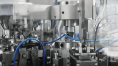 Fabrikada kozmetik ürünleri üretiliyor. El ve vücut kremi üretimi için taşıyıcı. Otomatik olarak kremalı plastik tüpler. Kremalı modern taşıyıcı. 