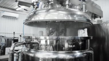 Kozmetik üretim tesisi. Fabrikada kozmetik hazırlamak için bir tank. Kozmetiklerle dolu bir konteynır. Şampuan üretimi, duş jelleri ve sıvı sabun..