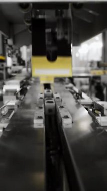 Bir şekerleme fabrikasında modern bir otomatik robot paketleyici. Robotla otomatik ürün ambalajı. Modern teknolojiler. Dikey video.