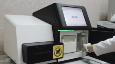 Laboratuvarda çalışan DNA sıralayıcısı. Bir araştırmacının eldivenli elleri sıralayıcıdaki analizleri için ayırıcı görevi görür. Yüksek teknoloji laboratuvar ekipmanları..