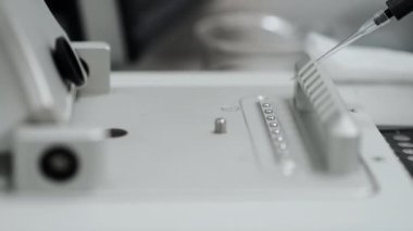 Nükleik asit frekans analizinin saptanması için numuneleri nanodrop içine damlatan otomatik bir pipetin yakın çekimi. Modern bilim laboratuarı. Laboratuvar için araştırma ekipmanları.