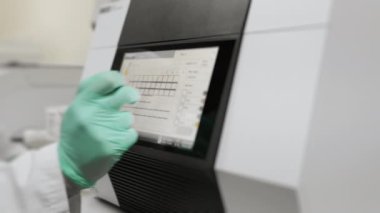 Laboratuvardaki bir bilim adamı gerçek zamanlı PCR için modern bir amplifikatörle çalışıyor. Modern ekipmanlar üzerinde PCR testi. Modern bilim laboratuarı. Laboratuvar için araştırma ekipmanları.