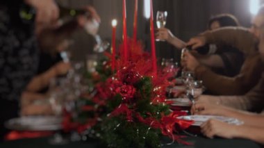 Bir grup genç Noel 'i neşeyle kutlar ve kadehlere şampanya dökerler. Yeni yılı ve Noel 'i kutluyoruz.