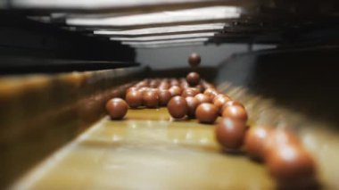 Çikolata fabrikasında taşıma bandı. Yumuşak çiğnenmiş karamel topları bir şekerleme fabrikasındaki taşıma bandına düşer. Şekerleme ve çikolata üretimi için şeker fabrikası.