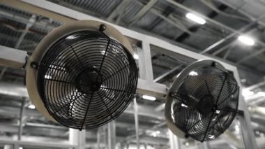 Soğutmak için iki büyük endüstriyel fan. Endüstriyel bir binada iki hayran. Fabrikadaki ürünlerin soğutulması.