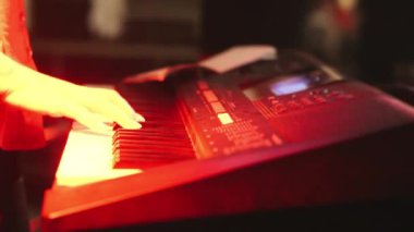 Klavye enstrümanı çalan bir müzisyenin ellerine yakın çekim. Bir müzisyen sentezleyici çalar. Elektronik piyano çalan bir müzisyen.