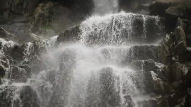 Dağ şelalesinin büyüleyici manzarası. Dağlardaki buzullardan akan bir dağ nehri..