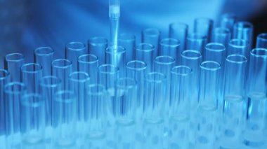 Bir bilim adamı laboratuardaki bir şişeden pipetle örnek alır. Araştırma laboratuarı. Sıvı numunesi üzerinde çalışıyorum. Araştırma ve Bilim.