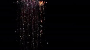 Duş başlığından gelen su, arka plandaki karanlık çekime dökülüyor. Banyodaki bir duş başlığından akan su. Karanlık bir arka planda su çekmek.