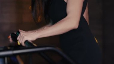 Egzersiz makinesinin basamaklarında yürüyen bir kız sporcunun bacaklarına yakın çekim. Spor üvey antrenörü. Bir kız spor salonunda antrenman yapıyor. Merdiven tırmanma egzersiz makinesi.