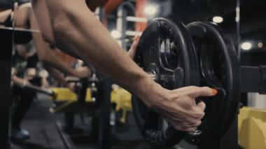 Dişi bir atlet halterden ağırlık kaldırır. Bir bayan atlet spor salonunda antrenman yapıyor. Modern spor salonu.