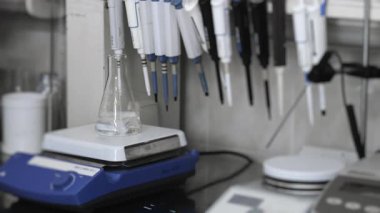 Bir laboratuvar manyetik mikser bilim laboratuarındaki cam şişede reaksiyonları karıştırıyor. Modern laboratuvar ekipmanları. Tıbbi ekipman. Laboratuvar araştırması için ekipman.