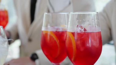 Bir barmen bir partide kokteyl hazırlar. Barmen bardakların içine pipet koyar. Kırmızı alkollü kokteyl. Kokteyl partisi..
