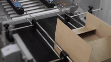 Modern fabrikadaki otomatikleştirilmiş üretim taşıma hattı. Üretim konveyör hattında karton taşıyorum. Karton kutular üretim konveyör hattında taşınıyor. Makine mekanizması.