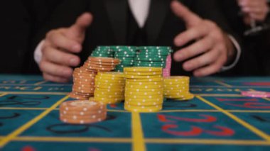 Kumar masasından kazandığı fişleri alan şanslı bir adamın elleri. Kumarhanede oynayan insanlar. Büyük bahisler Erkek eller kumarhaneden para kazanıyor..