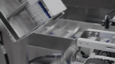 Otomatik robot paketleyici ilaç paketleme için karton kutuları besler. İlaç üretimi ve ambalajı için bitki. Bir ilaç fabrikasında otomatik ilaç ambalajı. 