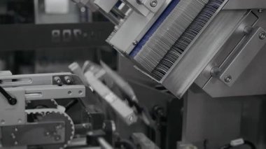 Otomatik robot paketleyici ilaç paketleme için karton kutuları besler. İlaç üretimi ve ambalajı için bitki. Bir ilaç fabrikasında otomatik ilaç ambalajı. 