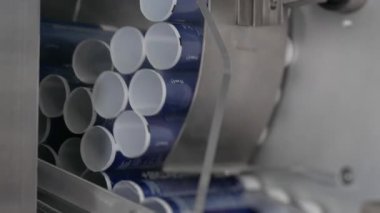 Fabrikada kozmetik ürünleri üretiliyor. El ve vücut kremi üretimi için taşıyıcı. Doldurucuya boş plastik krem tüpleri otomatik olarak besleniyor. Kremalı modern taşıyıcı. 