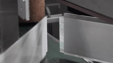 Taşıyıcı üzerinde hareket eden beyaz plastik şişelerin otomatik etiketlenmesi. Plastik şişe üretimi için bitki. Kozmetik üretim tesisi. Şampuan, duş jeli ve sıvı sabun üretimi. 