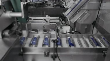 Kozmetik fabrikasında karton kutularda kremalı tüpler paketleme. Bir fabrikada kozmetik üretimi. Bir santralde otomatik paketleme hattı.