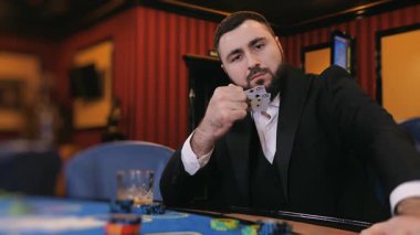 Poker oynayan sakallı bir adam. Oyuncu kumarhanede poker oynar. Kumarhane kavramı.