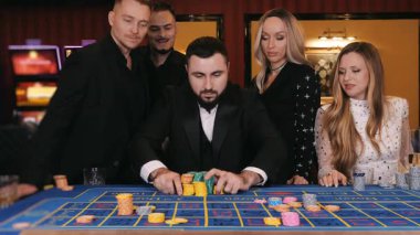 Kumarbazlar kumarhanede çok para yatırır. Kumarhane kavramı. Kumarhane bahsi. Kumarhanede kumar masasında çip taşıyan insanlar.. 