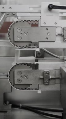 Kozmetik üretimi ve ambalaj fabrikası. Kozmetik için karton kutular. Kozmetik fabrikasında otomatik krem tüpleri. Karton kutu üretimi. Dikey video.