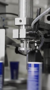 Fabrikada kozmetik ürünleri üretiliyor. El ve vücut kremi üretimi için taşıyıcı. Otomatik olarak kremalı plastik tüpler. Kremalı modern taşıyıcı. Dikey video.