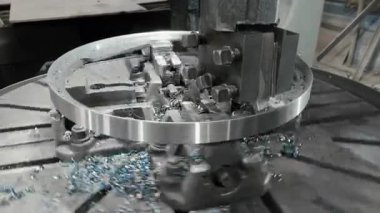 Metal ürünleri işlemek için dönen değirmen makinesi. Değirmen kesicisi bir metal işyerinde şekil kesiyor. Fabrika değirmen makinesi. Değirmen boyunca kıvılcımlar ve metal talaşları.