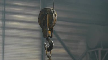 Fabrikada ya da depoda ağır yük taşımak için vinç kancasına yakın çekim. Ağır şeyleri taşımak için endüstriyel ekipman.