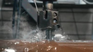 Matkap soğutmalı otomatik endüstriyel sondaj makinesi. Metal yapı fabrikasında kalın çelik borularda delik açmak. Endüstriyel ısıtma kazanı üretimi.