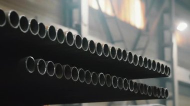 Çelik borular için modern endüstriyel fabrika. Demir yuvarlak boruları olan bir depo..