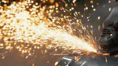 Metal kıvılcımları ağır sanayi fabrikasında üretiliyor. Metal fabrikasında çalışan bir işçi metali işliyor. Metal öğütme işlemi. Çelik fabrikası..
