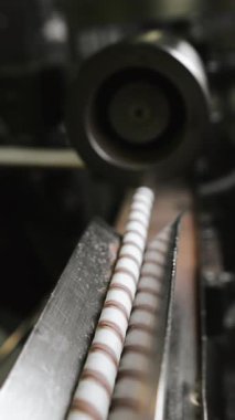 Çikolatalı gofret rulosu üretimi. Çikolatalı waffle ruloları bir şekerleme fabrikasında konveyör boyunca ilerler. Yiyecek endüstrisi. Dikey video.