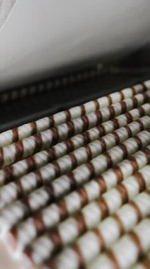Çikolatalı gofret rulosu üretimi. Çikolatalı waffle ruloları bir şekerleme fabrikasında konveyör boyunca ilerler. Yiyecek endüstrisi. Dikey video.