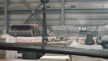 Bir endüstriyel vinç fabrika zemininde işlemek için metal borular taşır. Metal ürünleri deposu.