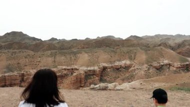 İki turist, bir anne ve oğul, bir uçurumun kenarına yaklaşıyorlar ve ulusal parktaki bir kanyonun güzel manzarasına hayran kalıyorlar..