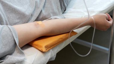Modern bir tıp kliniğinde kadın elinin bir damla ilaçla yakın çekimi. Hastanedeki bir hastaya damardan ilaç verilmesi..